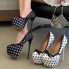 Model wearing black polka dot platform pumps
