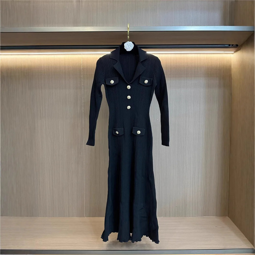 Black coat with white buttons on a hanger against a wooden background