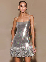 Model wearing a silver sequin dress with floral details on a beige background