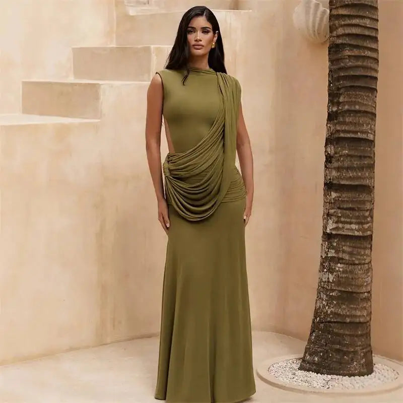 Model wearing a green draped mock neck sleeveless maxi dress in an outdoor setting