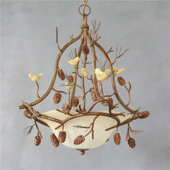 Decorative chandelier with branches, birds, and pinecones on a gray background