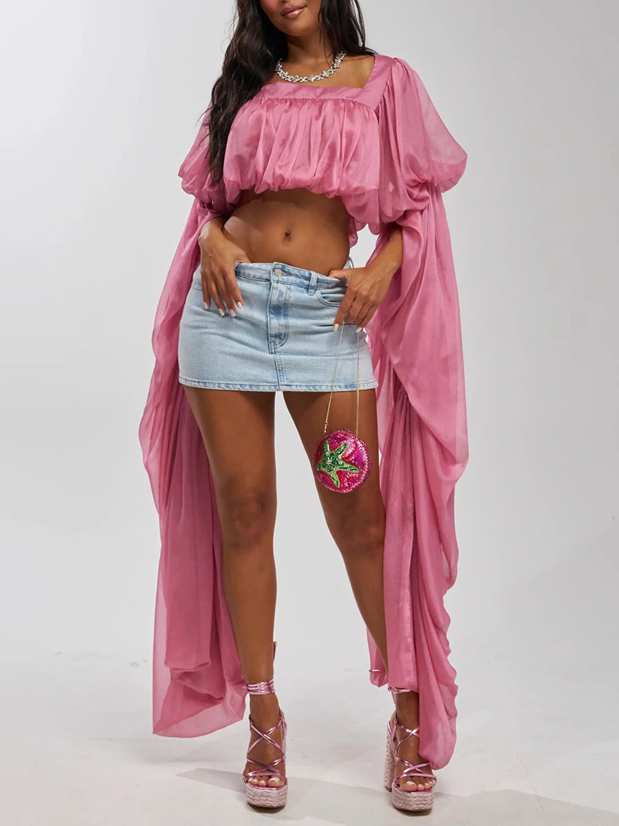Pink draped square neck crop top with long flowing sleeves and a mini denim skirt.