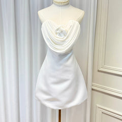 White strapless mini dress on mannequin with sculpted rose applique and draped front
