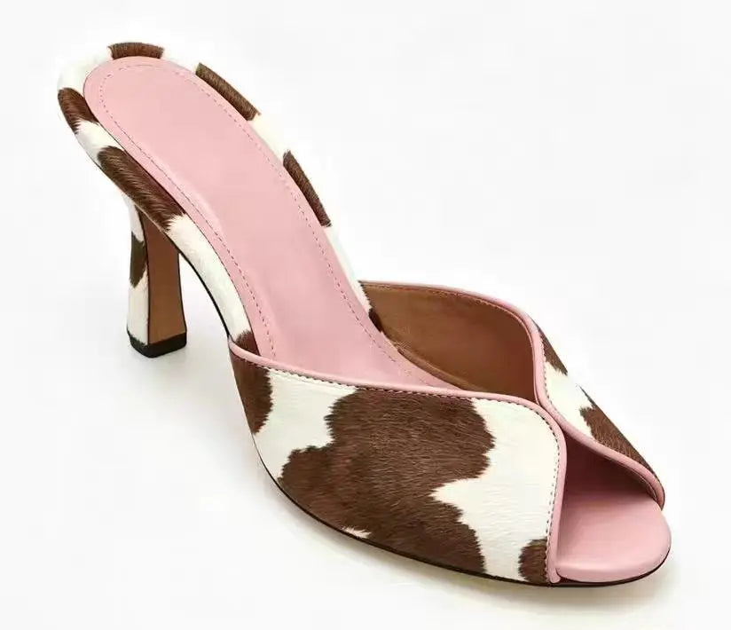 Cow print mule heels with pink trim and light blue insole