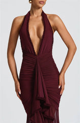 Maroon halter neck dress with deep neckline on a model against a light gray background