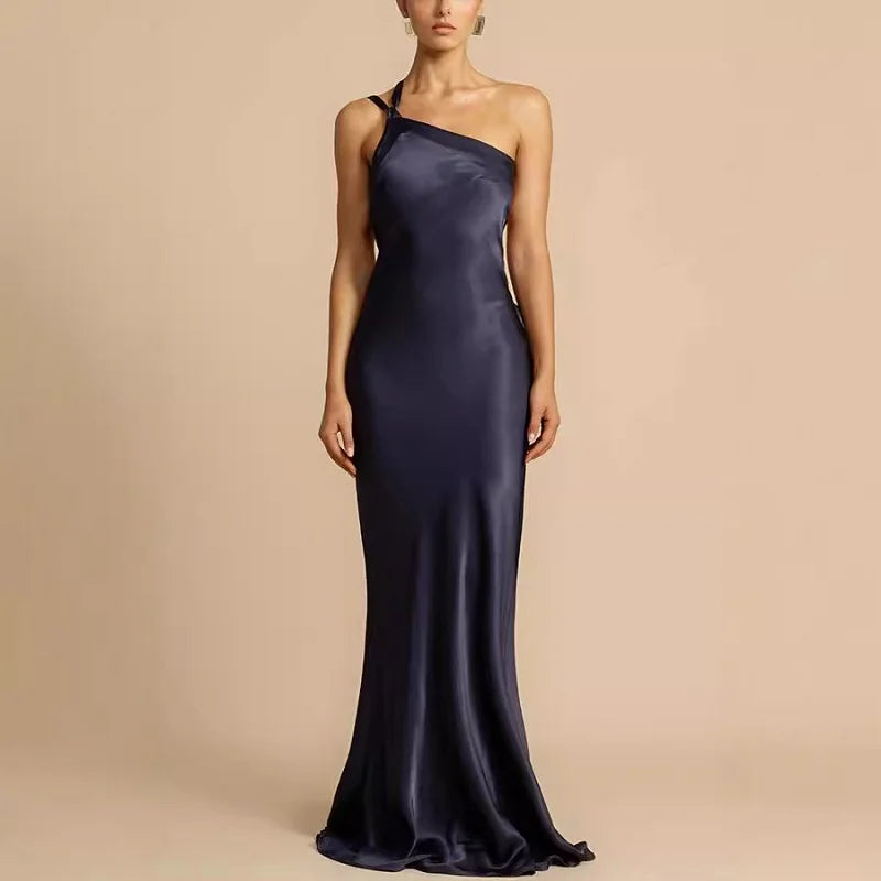 Navy one-shoulder gown on a beige background