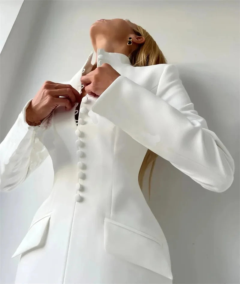 Person wearing a white suit with a plain background