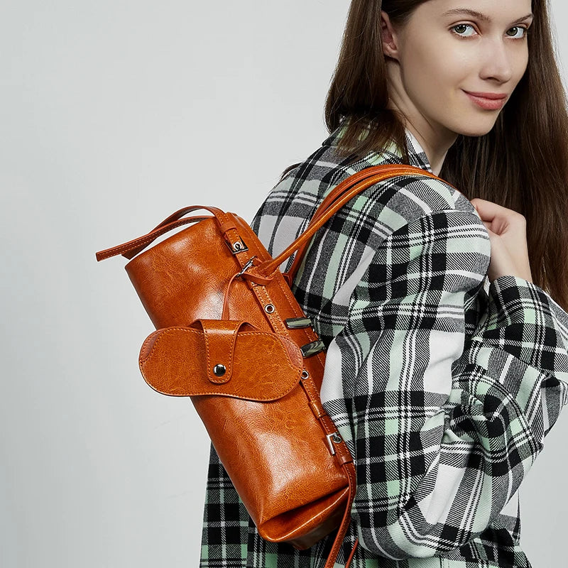 Woman wearing a brown leather backpack on a plain background