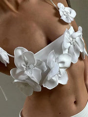 White floral bikini top worn by a person against a neutral background