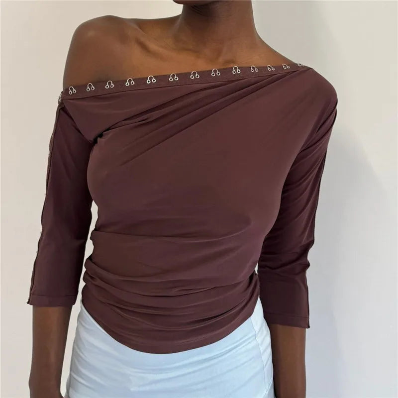 Brown off-shoulder top with decorative trim on a plain background