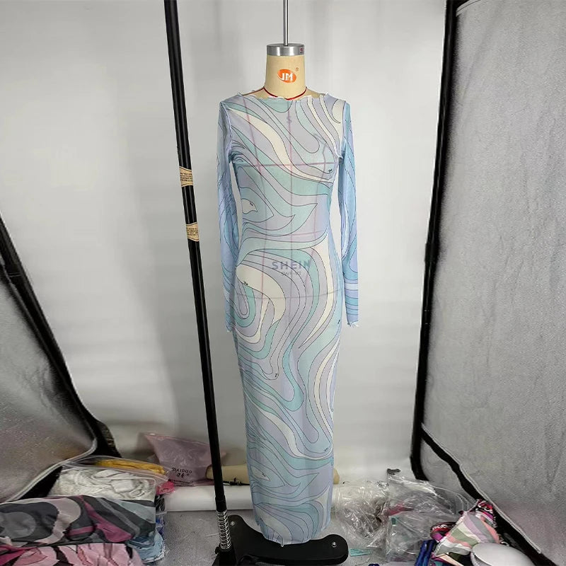 Mannequin wearing a patterned dress in a studio setting with lighting equipment.