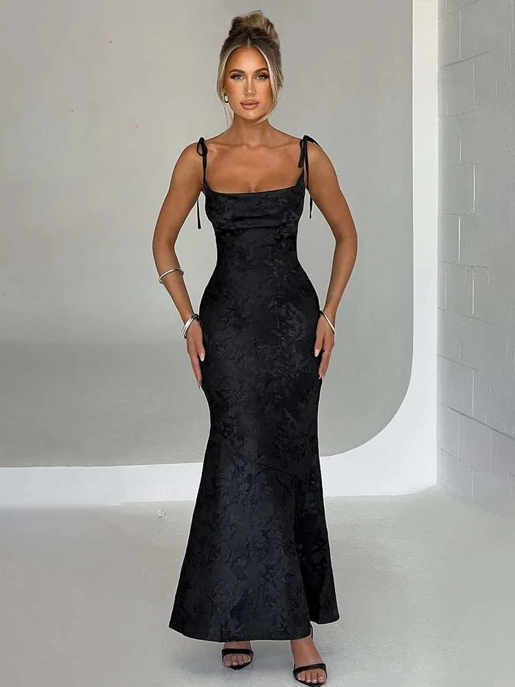 Woman wearing a black evening gown against a neutral background