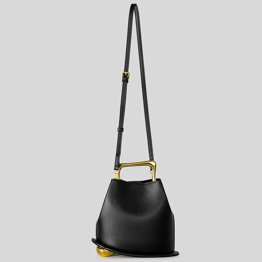 Black handbag with gold accents on a light gray background