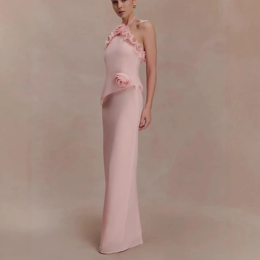 Woman wearing a pink evening gown with floral details on a beige background