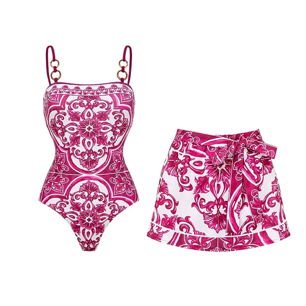 Pink and white floral print one-piece swimsuit and skirt set laid flat.