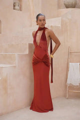 Woman in a red evening gown standing in a neutral-colored room.