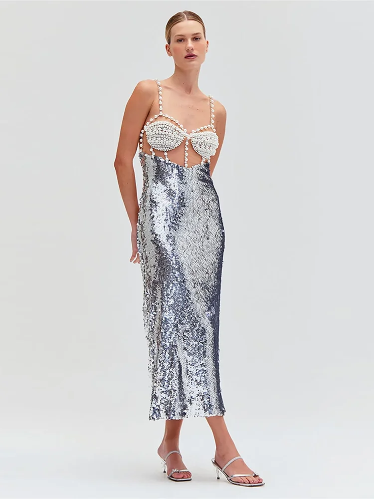 Woman wearing a silver sequin dress with a white lace top on a light gray background