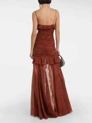 Woman wearing a rust-colored dress with ruffled layers on a white background