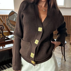 Brown ribbed sweater with gold buttons worn by a person indoors.