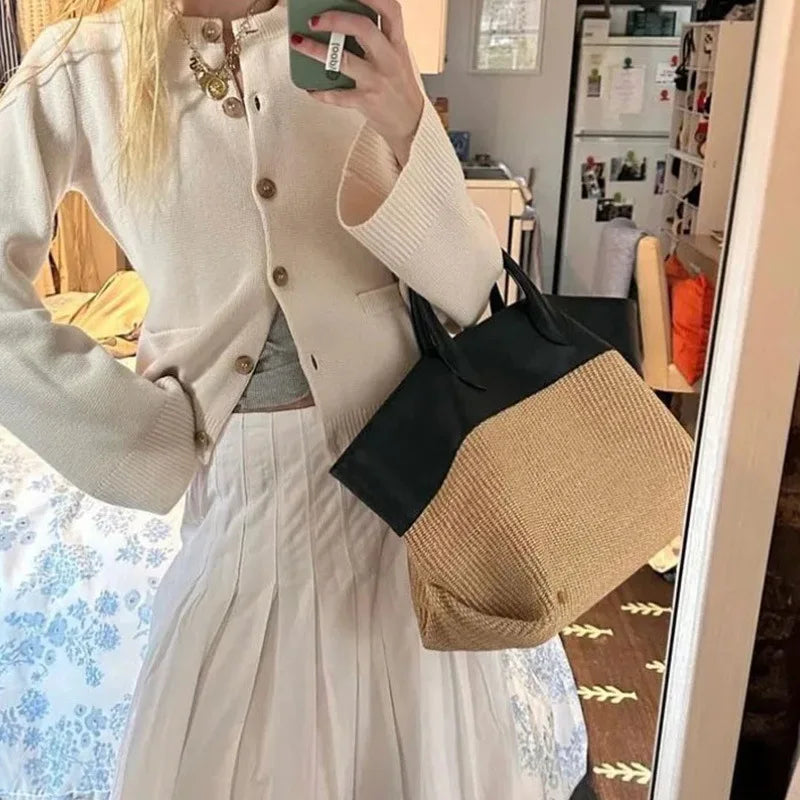Woman with a colorblock tote bag, close-up of straw and leather
