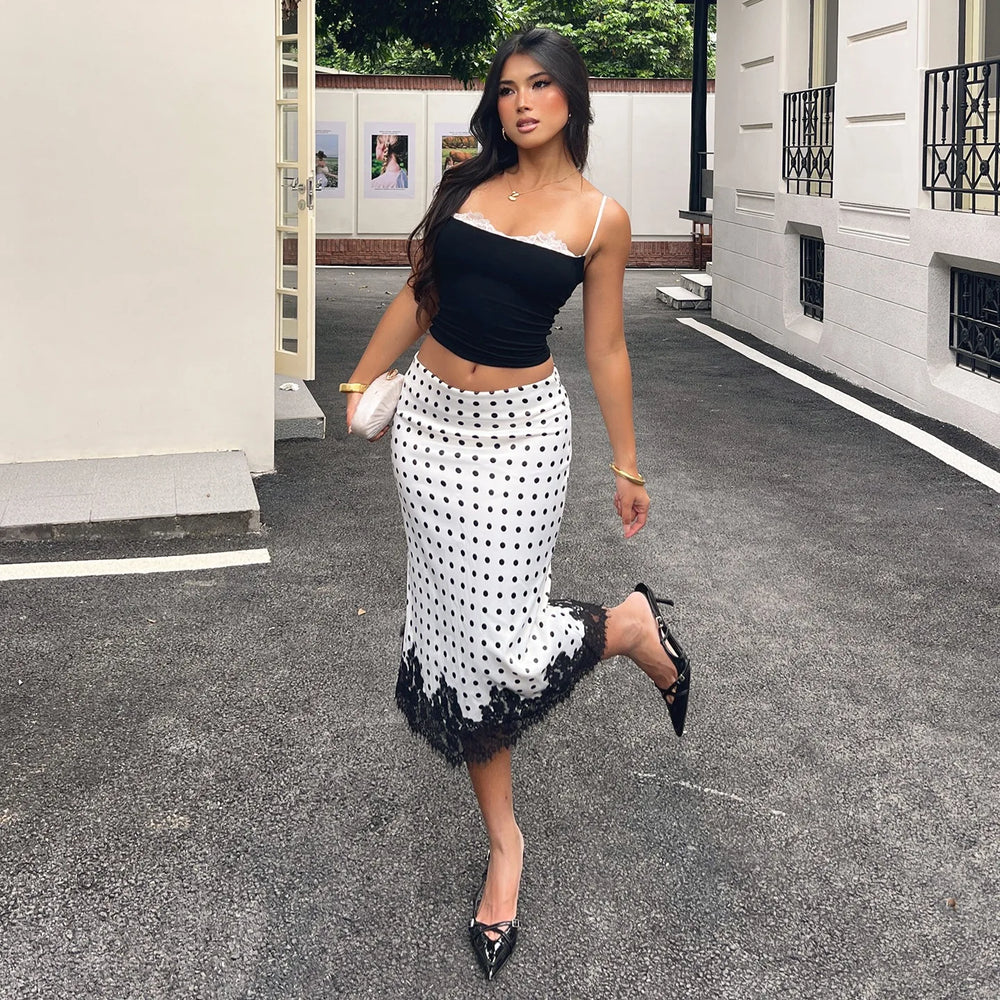 Woman in a black and white polka dot skirt walking on a street.