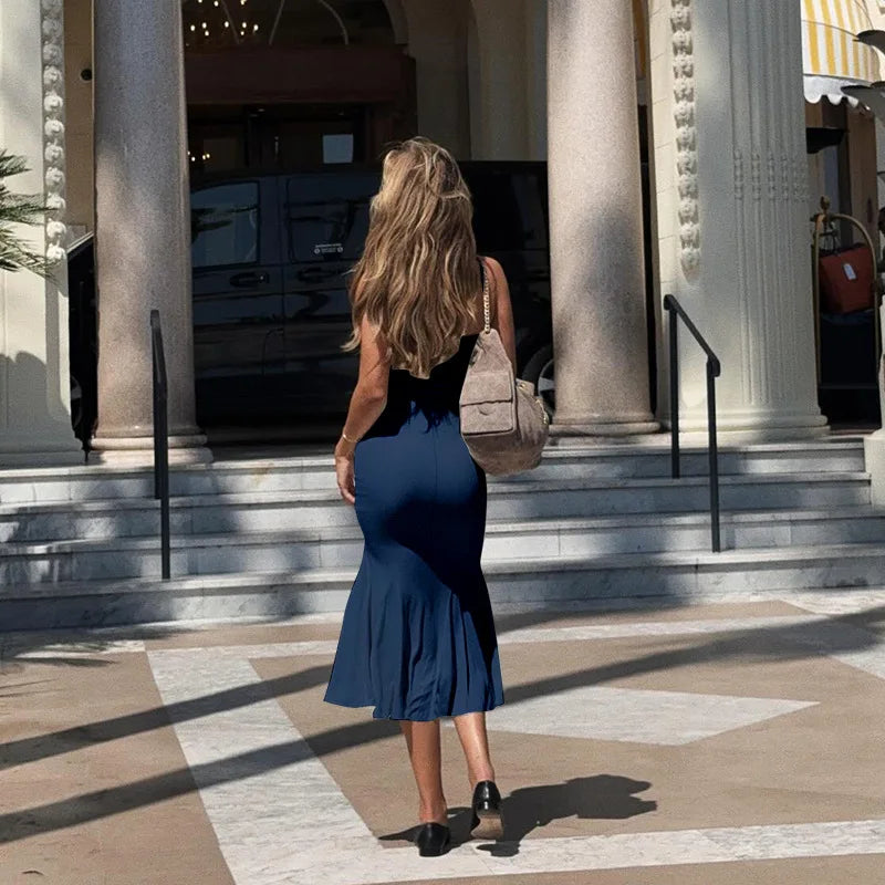 Woman in a blue dress standing on steps in front of classical architecture