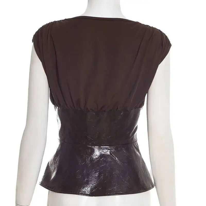 Mannequin wearing a brown leather top with a plain background
