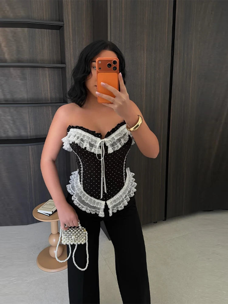 Close-up of a model wearing a black polka dot lace corset top.