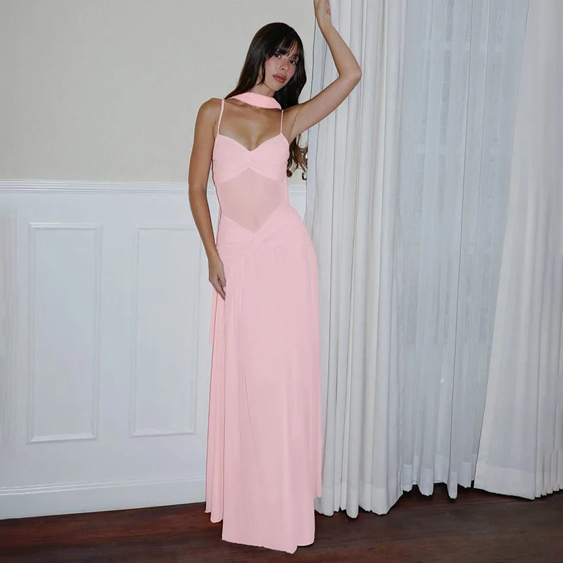 Woman wearing a pink evening gown in a room with white walls and curtains.