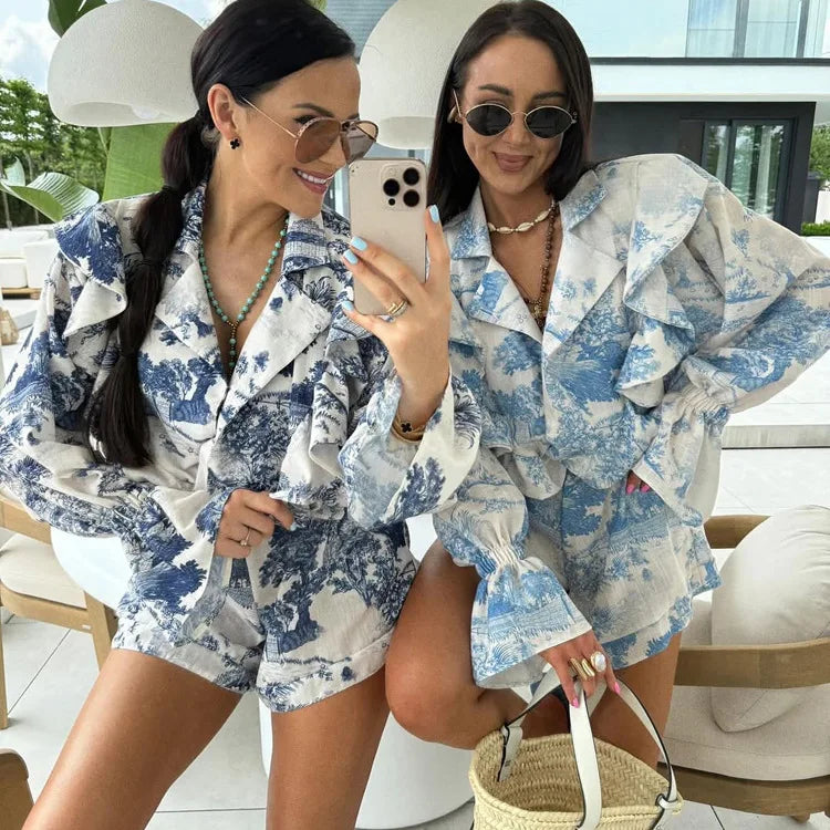 Two women in matching blue and white floral outfits taking a selfie.