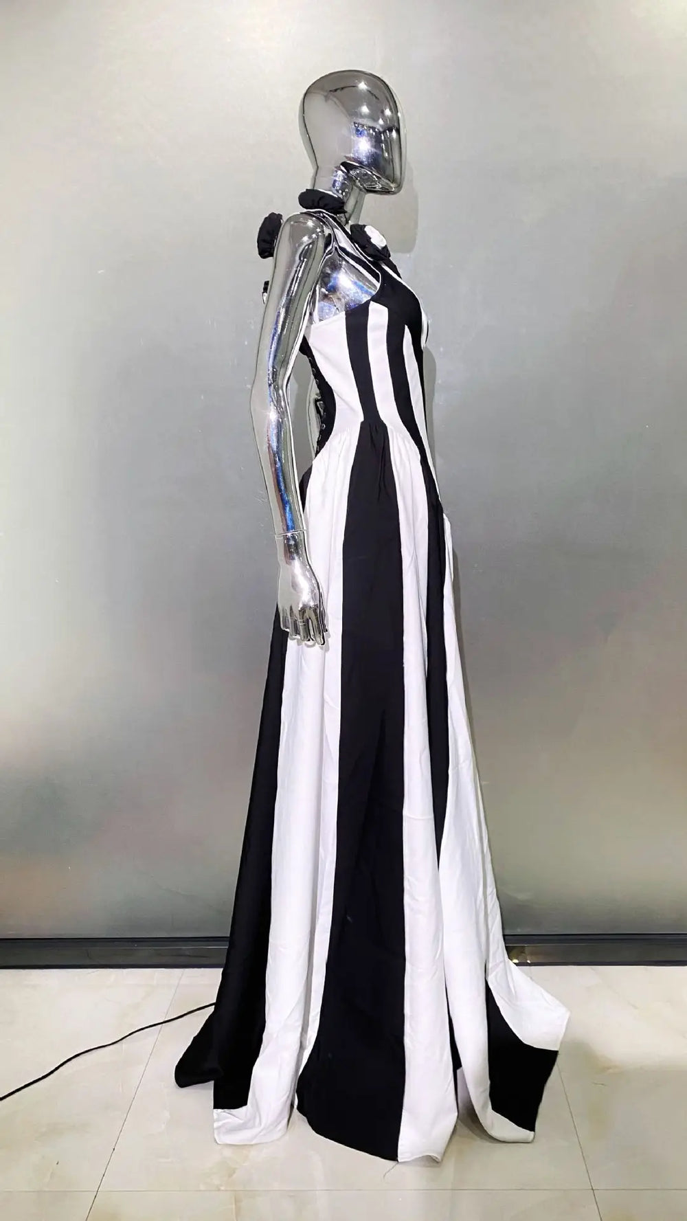 Mannequin wearing a black and white striped dress against a neutral background