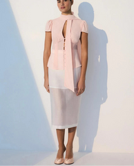 Woman wearing a pink blouse and white skirt with a blurred background