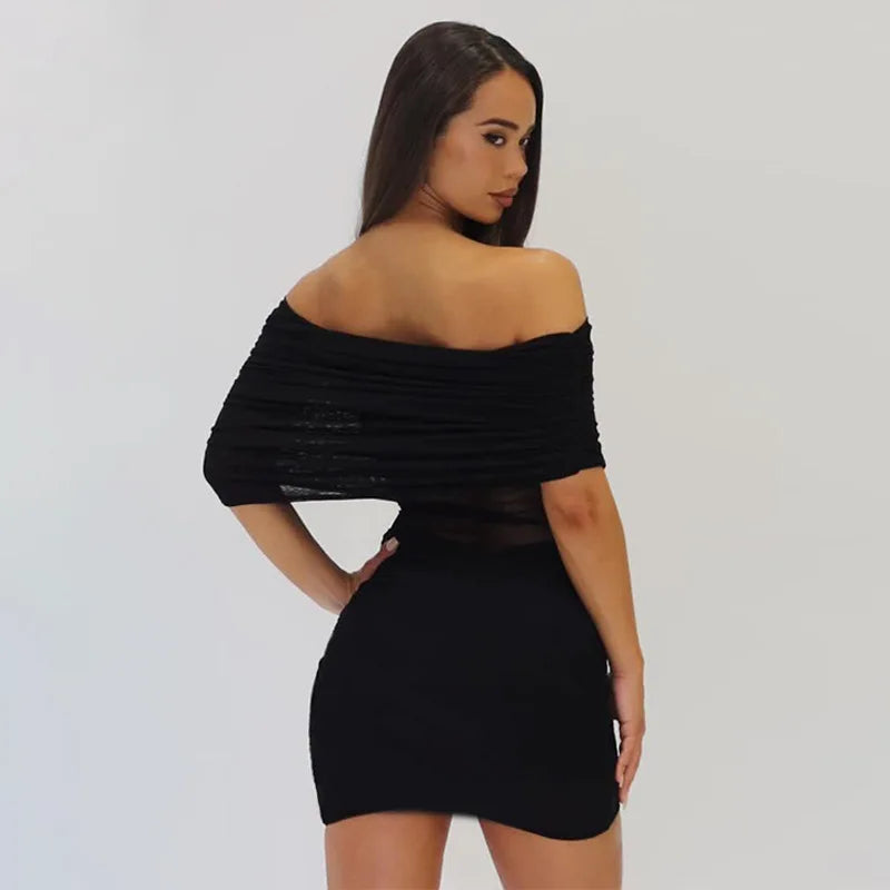 Woman wearing a black off-shoulder dress against a plain background