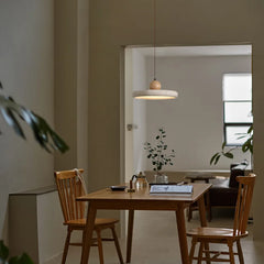 A retro travertine pendant light with a warm yellow glow illuminating a Dining Table