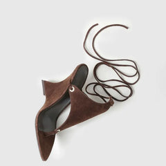 Brown suede sandals with a long strap on a light grey background
