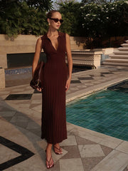 Woman in a brown dress standing by a poolside