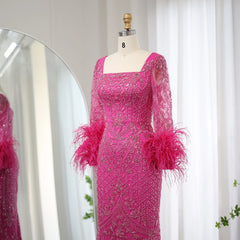 Mannequin displaying a glamorous fuchsia evening gown with delicate feather embellishments and long sleeves. Golden Atelier 3