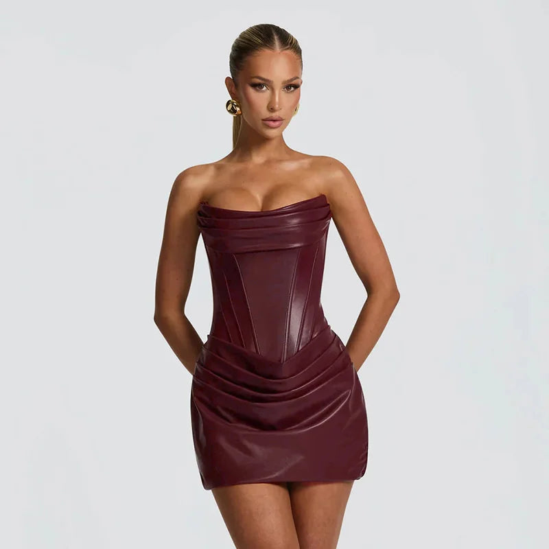 Woman wearing a strapless burgundy dress against a plain background