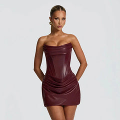 Woman wearing a strapless burgundy dress against a plain background