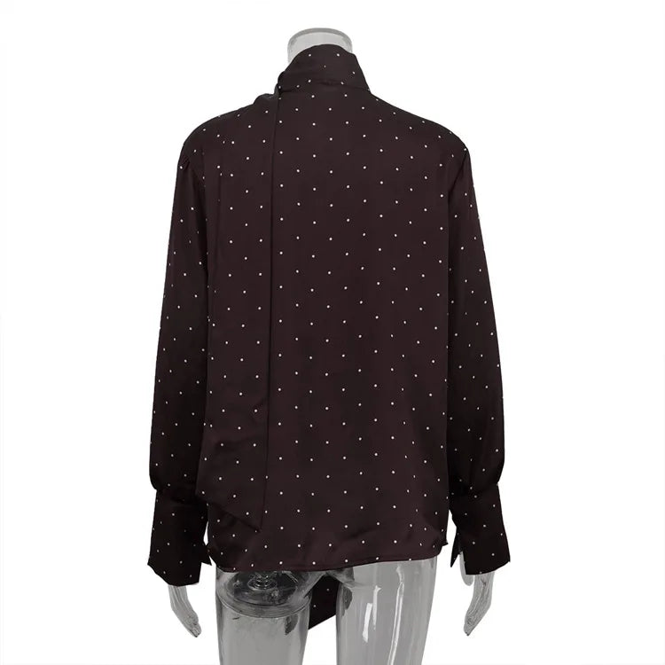 Black shirt with white polka dots on a mannequin against a white background