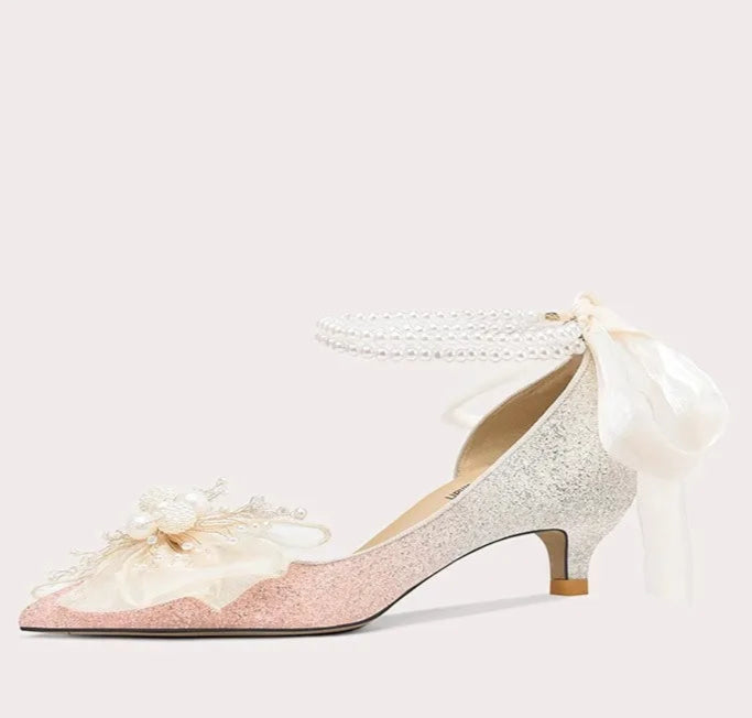 White high-heeled shoe with a bow on a light gray background