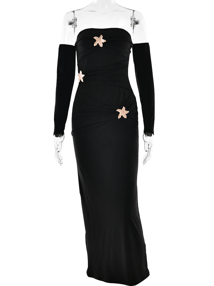 Black evening gown with floral embellishments on a mannequin against a white background