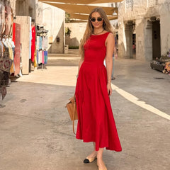 Woman in a red dress standing in an outdoor market area.