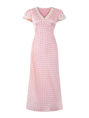 Pink polka dot dress with lace trim on a white background