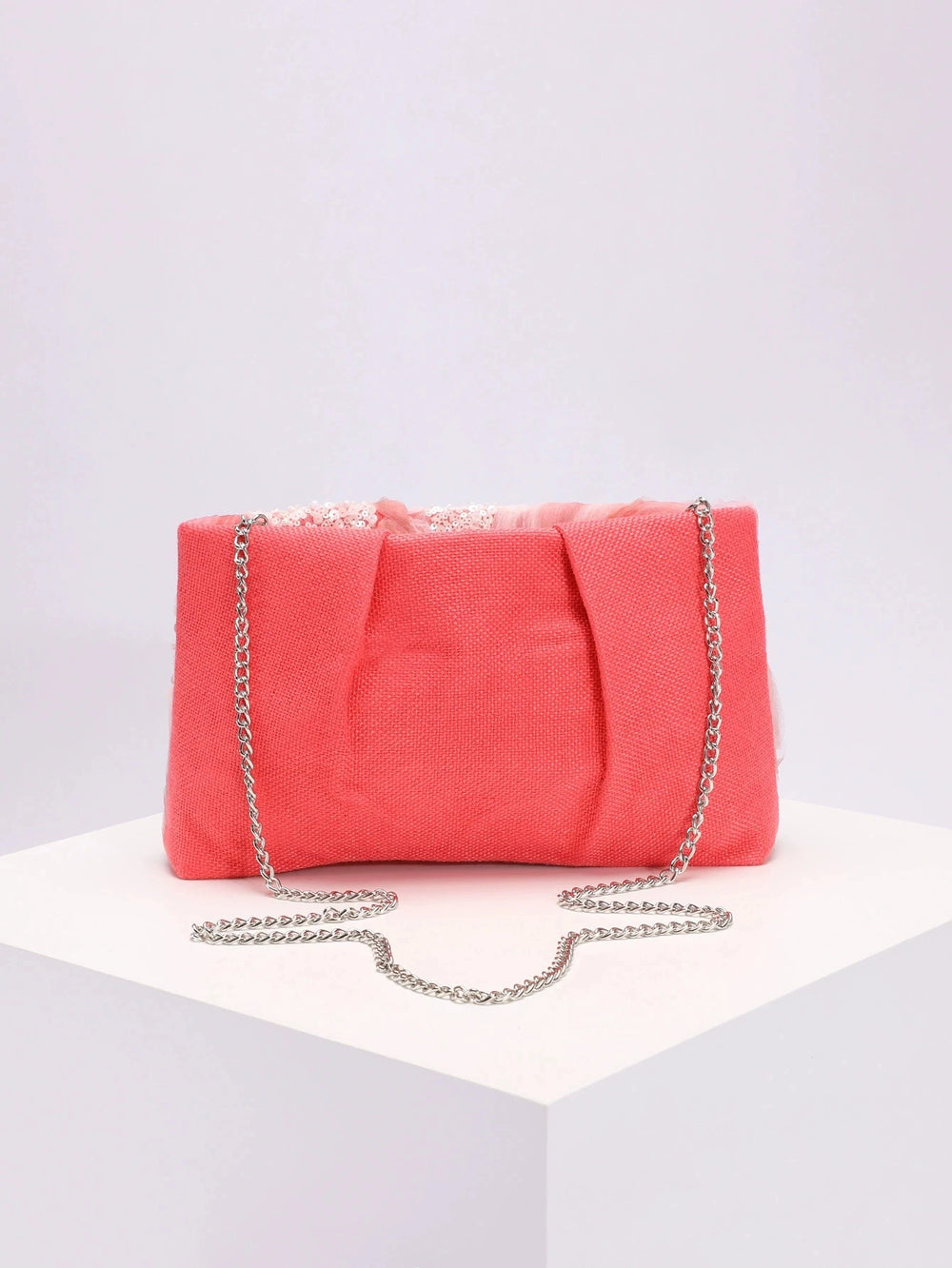 Pink clutch bag with a chain strap on a light gray background