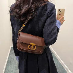 Designer crossbody handbag with flap-lock closure and versatile strap