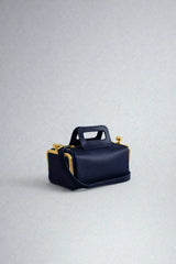 Navy blue handbag with gold accents on a light gray background