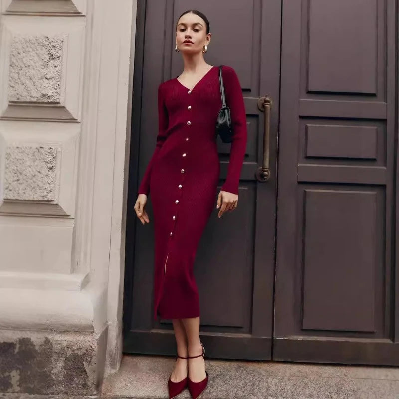 Woman in a burgundy dress standing in front of a large door.