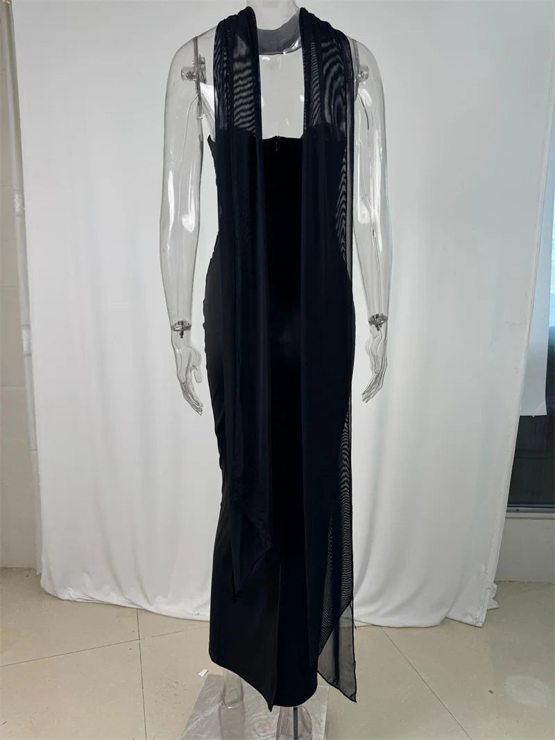 Black dress with sheer panels on a mannequin against a white curtain background