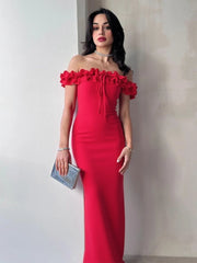 Woman wearing a red off-shoulder dress against a plain background